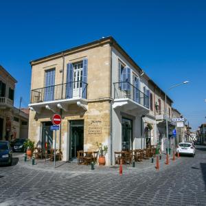 ein Gebäude mit Tischen und Stühlen auf einer Straße in der Unterkunft Nautica Luxe Heritage in Larnaka