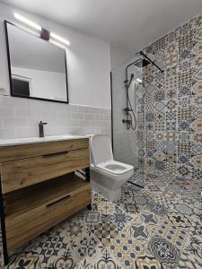 un bagno con lavandino, WC e specchio di FurtuNest 