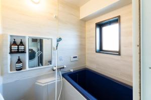a bathroom with a large blue tub in a room at AMP FLAT MOMOCHi in Fukuoka +44 photos