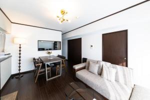 a living room with a couch and a table at AMP FLAT MOMOCHi in Fukuoka