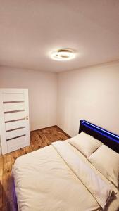a bedroom with a bed and a ceiling with a light at GOLD APARTAMENT Ząbki in Ząbki