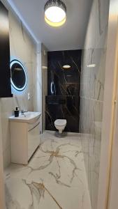 a bathroom with a sink and a toilet at GOLD APARTAMENT Ząbki in Ząbki +8 photos