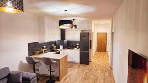 a kitchen with a table and a refrigerator at GOLD APARTAMENT Ząbki in Ząbki