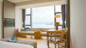 Una habitación de hotel con una cama, un sofá y una ventana. en Hotel Indigo Dali Erhai by IHG, en Dali