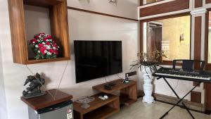 ein Wohnzimmer mit Fernseher und Keyboard in der Unterkunft Luxstay kochi in Kochi