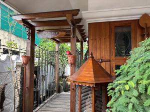 ein Holzgebäude mit einem Vogelkäfig auf einem Gehweg in der Unterkunft Luxstay kochi in Kochi