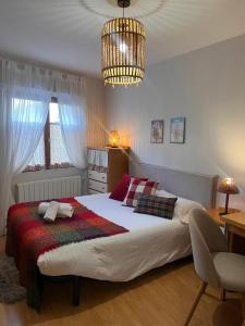 a bedroom with a large bed and a chandelier at Casa Marilu Sallent in Sallent de Gállego