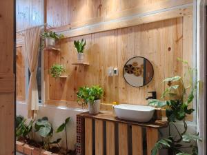 a bathroom with a sink and plants on a wooden wall at MOre home 2 - ngôi nhà nghĩ dưỡng tại Đà Lạt in Da Lat