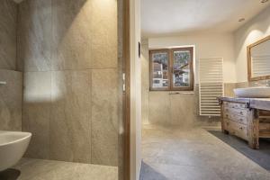 a bathroom with a shower and a sink and a tub at Tieja Panoramic Lodge in Selva di Val Gardena +87 photos