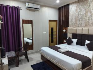a bedroom with a bed and a chair and a mirror at The Five D in Agra +10 photos