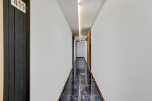 a corridor in a building with black tiles at Collection O Adajan Formerly Hotel Sky Palace in Surat