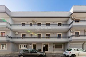 due auto parcheggiate davanti a un edificio di Silver Bay Apartments a Porto Cesareo