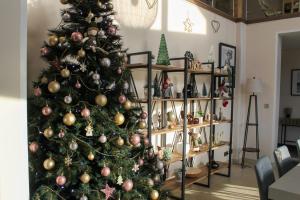 a christmas tree with ornaments on it in a living room at Le Clos des Cigognes - Architect-designed house near Omaha Beach in Trévières