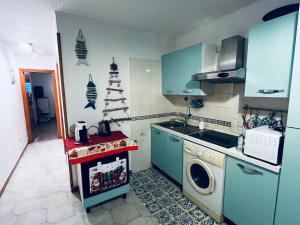 een keuken met een wasmachine en een kerstboom bij Casa Stella Marina in Anzio +14 foto's
