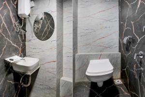 a bathroom with a toilet and a sink at Collection O Adajan Formerly Hotel Sky Palace in Surat