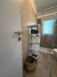 a bathroom with a shower and a shelf with towels at MH Lippolis in Bari +13 photos