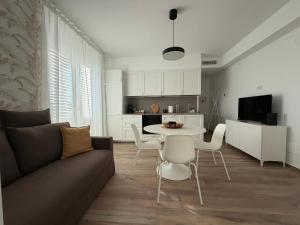 a living room with a couch and a table and chairs at MH Lippolis in Bari
