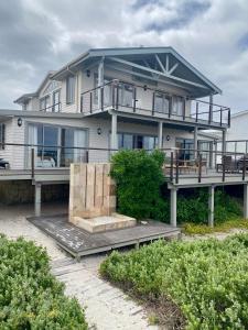 una grande casa bianca con un ampio ponte di Dune Rose Yzerfontein Villa a Yzerfontein