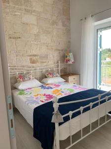 una camera da letto con un letto bianco e un muro di mattoni di villa Elaionas a Tsivarás Altre 24 foto