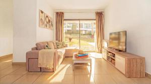 a living room with a couch and a tv at Cavalo Preto Ocean Breeze Apartment in Forte Novo Quarteira in Quarteira