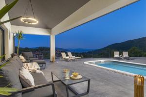 een woonkamer met een bank en een zwembad bij Villa Mantis by Briskva in Martina