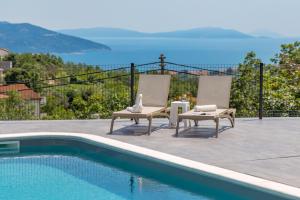 een patio met 2 stoelen en een zwembad bij Villa Mantis by Briskva in Martina