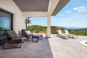 een patio met stoelen en uitzicht op de bergen bij Villa Mantis by Briskva in Martina
