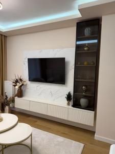 a living room with a television on a wall at Palata Royal Banja Luka Luxury Apartment in Banja Luka