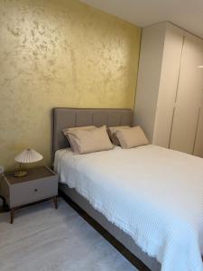 a bedroom with a bed and a table with a lamp at Palata Royal Banja Luka Luxury Apartment in Banja Luka