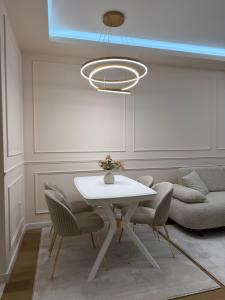 a dining room with a white table and chairs at Palata Royal Banja Luka Luxury Apartment in Banja Luka