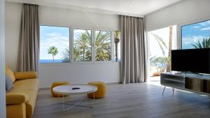 Una sala de estar con un sofá y un televisor. en Deva Beach Boutique Apartments, en San Fernando