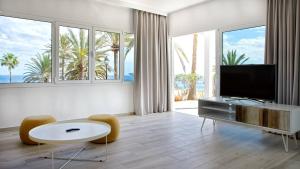 Una sala de estar con televisión, mesa y sillas. en Deva Beach Boutique Apartments, en San Fernando 24 fotos más