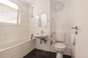 ein weißes Badezimmer mit Toilette und Waschbecken in der Unterkunft MK Apartments Delmenhorst nähe Bremen 3 in Delmenhorst