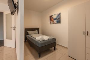 ein kleines Schlafzimmer mit einem Bett in einem Zimmer in der Unterkunft MK Apartments Delmenhorst nähe Bremen 3 in Delmenhorst