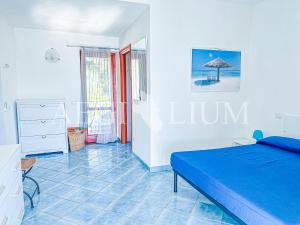 a bedroom with a blue bed and a blue tile floor at Villa Giglio Rosso in Campese