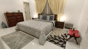 een slaapkamer met een bed en een rode stoel bij Home sweet home in Abbottābād