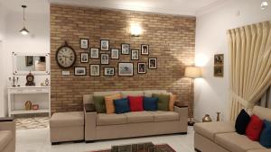 een woonkamer met 2 banken en een bakstenen muur bij Home sweet home in Abbottābād