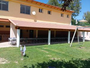 un edificio con portico attrezzato con tavoli e sedie di Camping Las Aguas  Altre 4 foto