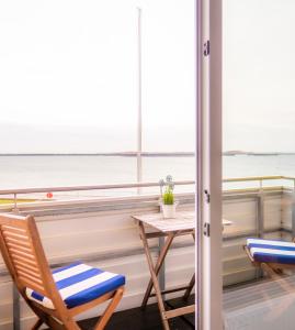 Una mesa y sillas en un balcón con vista al mar. en Miramar, en Helgoland