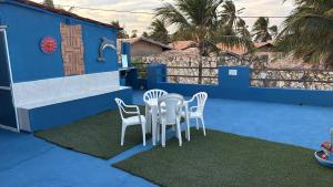 een tafel en stoelen op een blauw terras bij Casa Cochilo na Rede in Beberibe