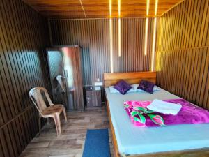 a bedroom with a bed with purple sheets and a chair at Kanchenjunga Vista Pabong in Sāmthar +15 photos