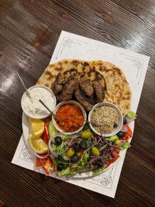 a plate of food with meat and a salad with dips at Restoran Tron in Petrovac na Mlavi