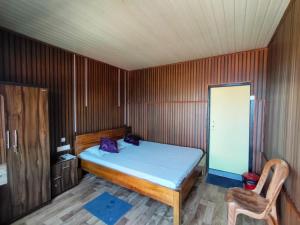 a small bedroom with a bed and a chair at Kanchenjunga Vista Pabong in Sāmthar