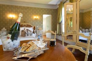 een kamer met een tafel, een fles wijn en brood bij Château de Luzières in Conty