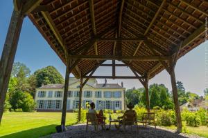 twee vrouwen aan een tafel voor een huis bij Château de Luzières in Conty