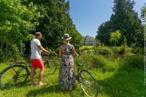 een man en een vrouw die naast een fiets staan bij Château de Luzières in Conty