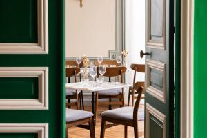 ein Esszimmer mit einem Tisch mit Weingläsern in der Unterkunft Le Charmant Hôtel in Saint-Ouen + 14 Fotos