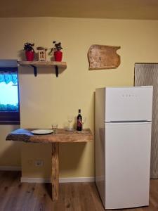 a kitchen with a table and a white refrigerator at Casa del Borgo in Bellano