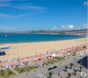 a beach with a lot of people and the ocean at Appart Hotels Wouroud in Tangier