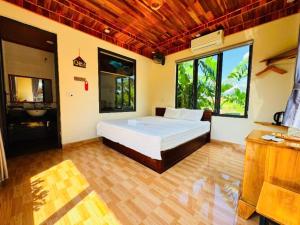 ein Schlafzimmer mit einem Bett in einem Zimmer mit Fenstern in der Unterkunft Ninh Binh Royal Bungalow in Xuân Sơn